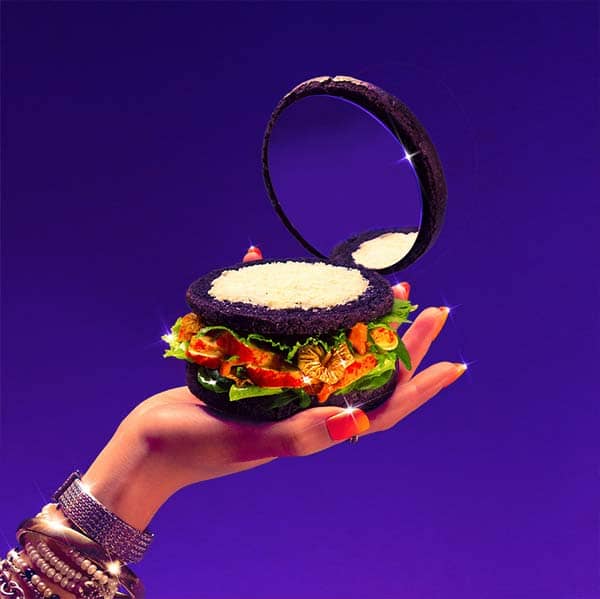 hand holding a brurger with a mirror