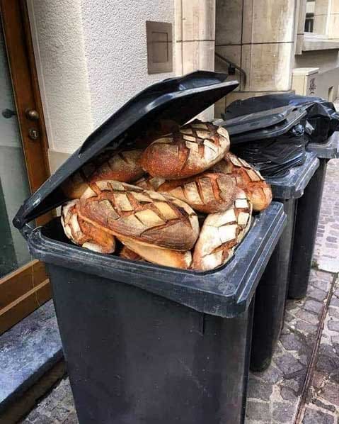 Black waste bin full of edible bread